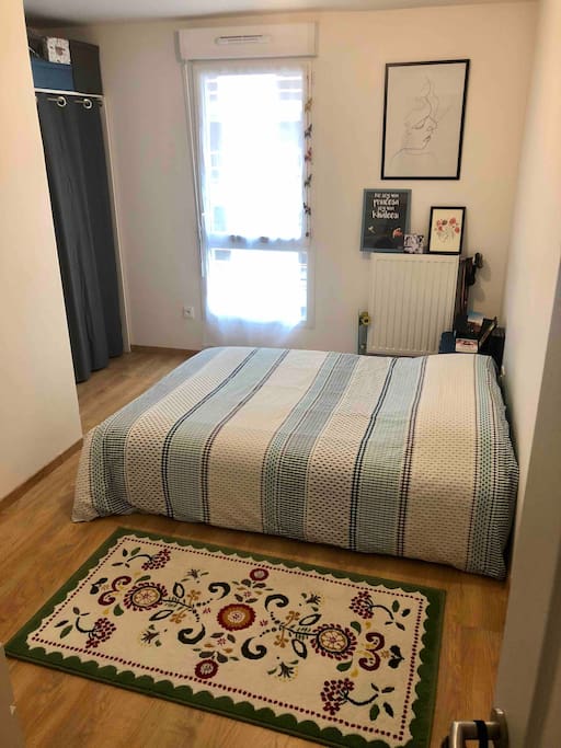 Chambre de 12m² avec un canapé-lit, un meuble-rangement.
