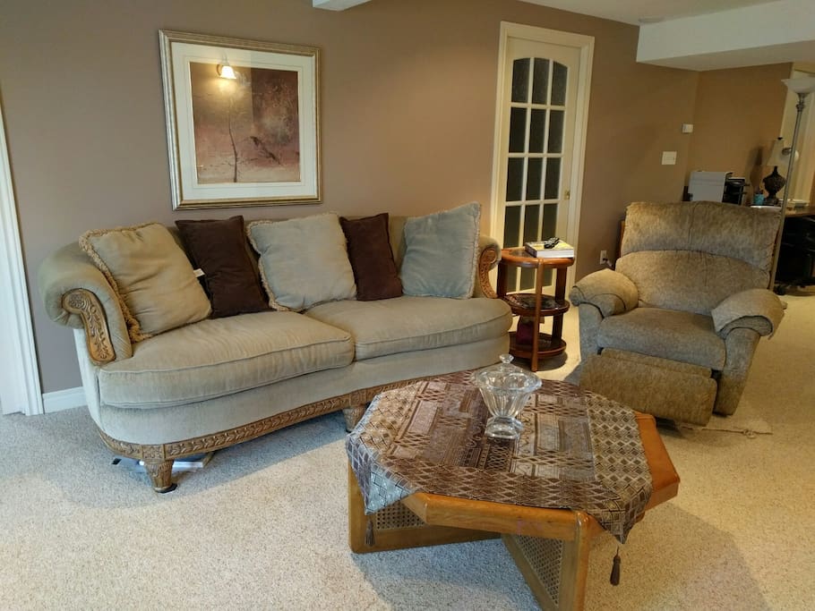Large living room with ample seating, gas fireplace and walk out to private patio, facing large pond