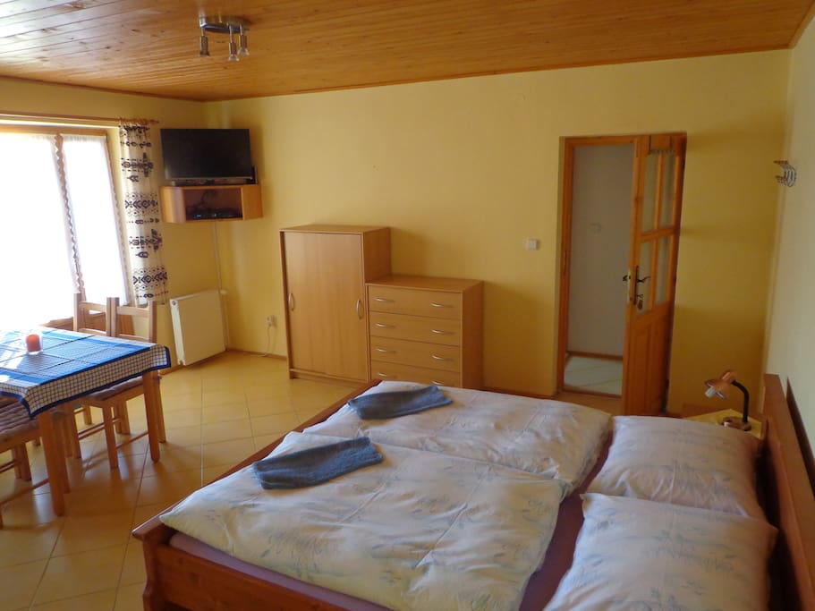 Large room with three beds and dinning table