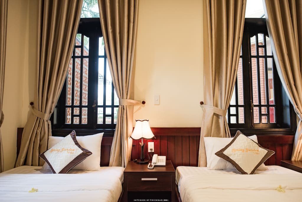 This bedroom has many windows with garden view, natural lights.