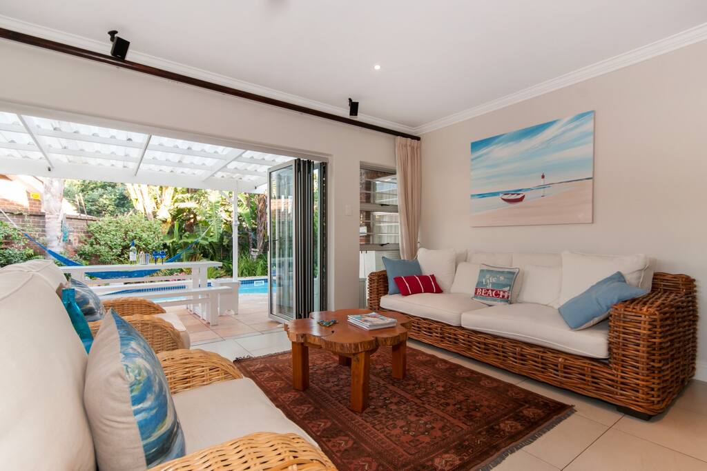 Tv room with stacker doors looking out onto cover patio and pool area