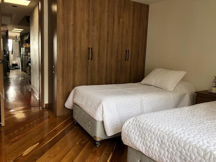 Segunda habitación con dos camas individuales que se pueden armar para hacer una cama tamaño king. This room also has exit to the balcony // Segundo cuarto con dos camas sencillas que se pueden unir para formar una cama king. También tiene salida al balcón.