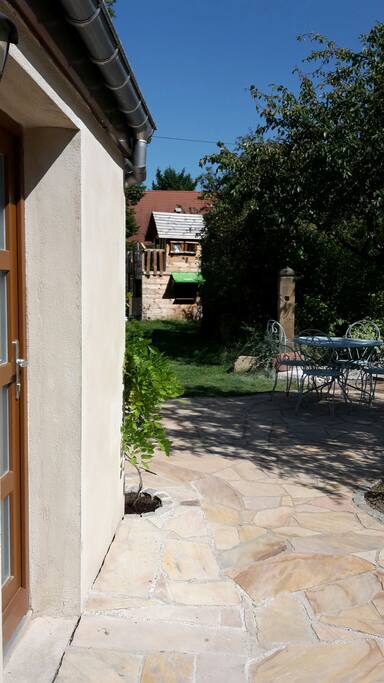 Vue de la terrasse avant et du jardin depuis l'entrée de la maison