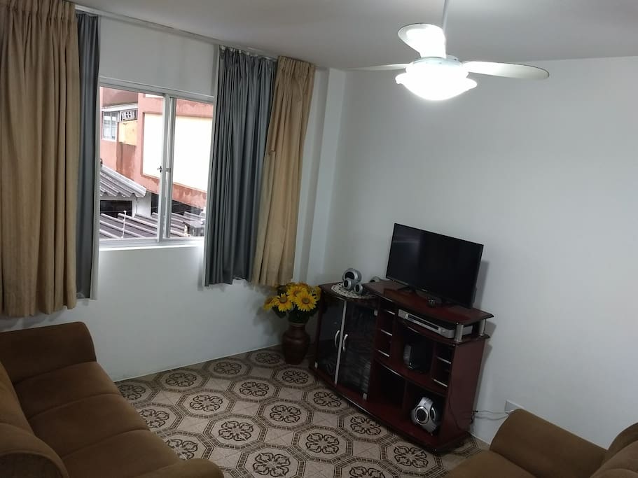 sala com TV, ventilador de teto, sofá