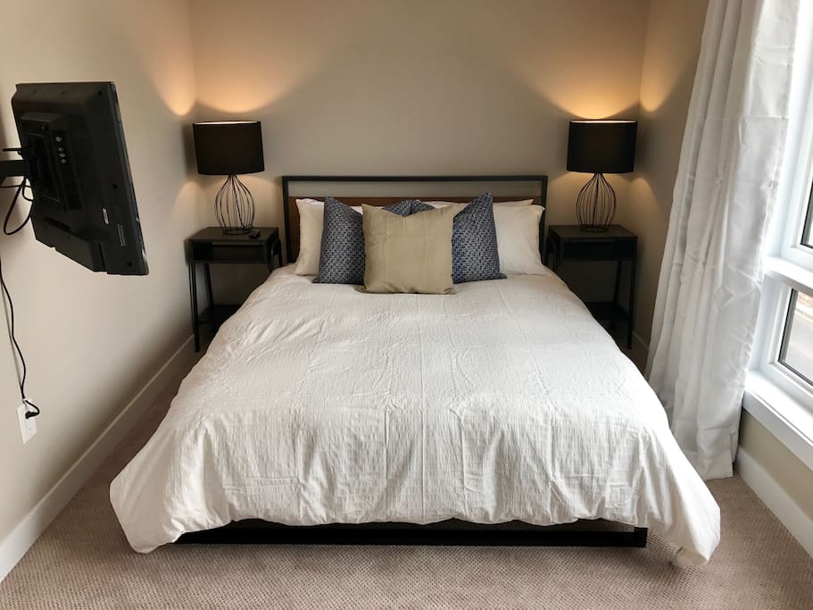 Cozy queen bedroom with black-out curtains for a quiet, restful sleep