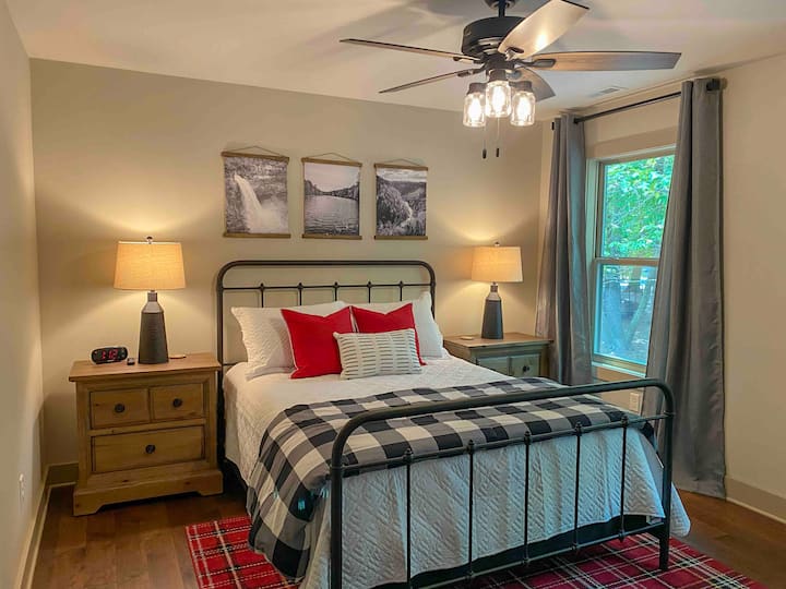 Upstairs private bedroom with queen bed, closet, luggage rack, dresser, tv, and semi-private attached bathroom with walk in shower. 