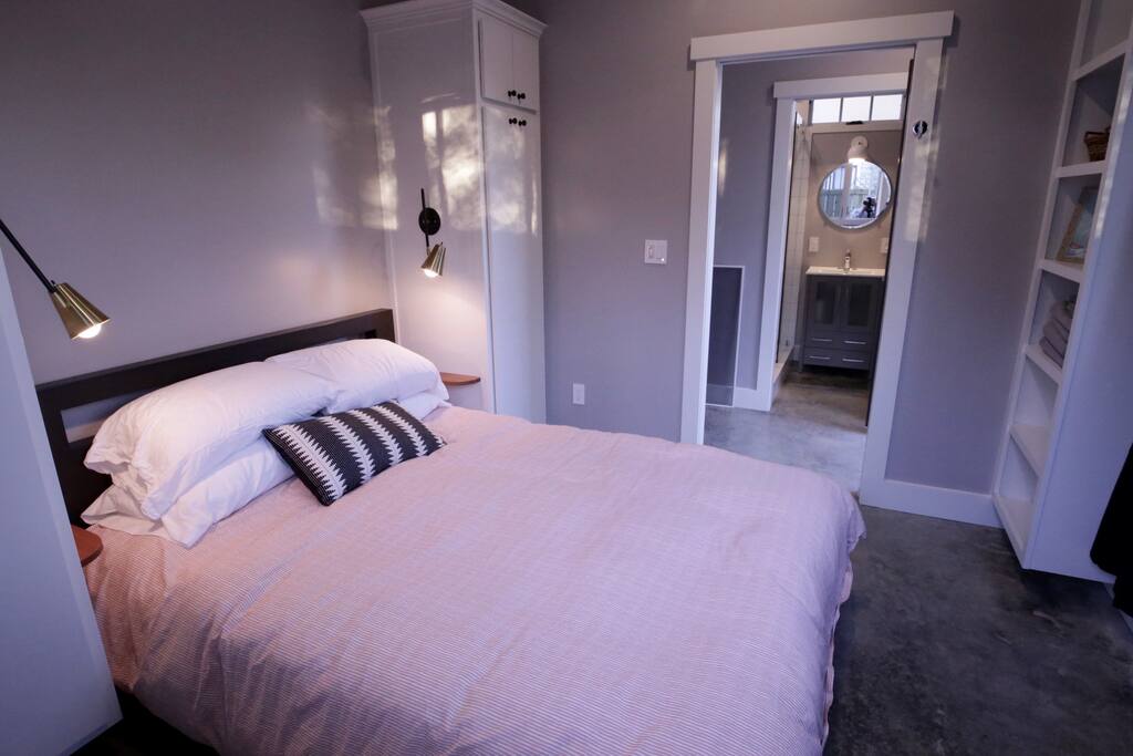 Cozy bedroom with two built-in cabinets with room for hanging clothes. A ceiling fan, and two large windows for light (and black out curtains for a quiet sleep).