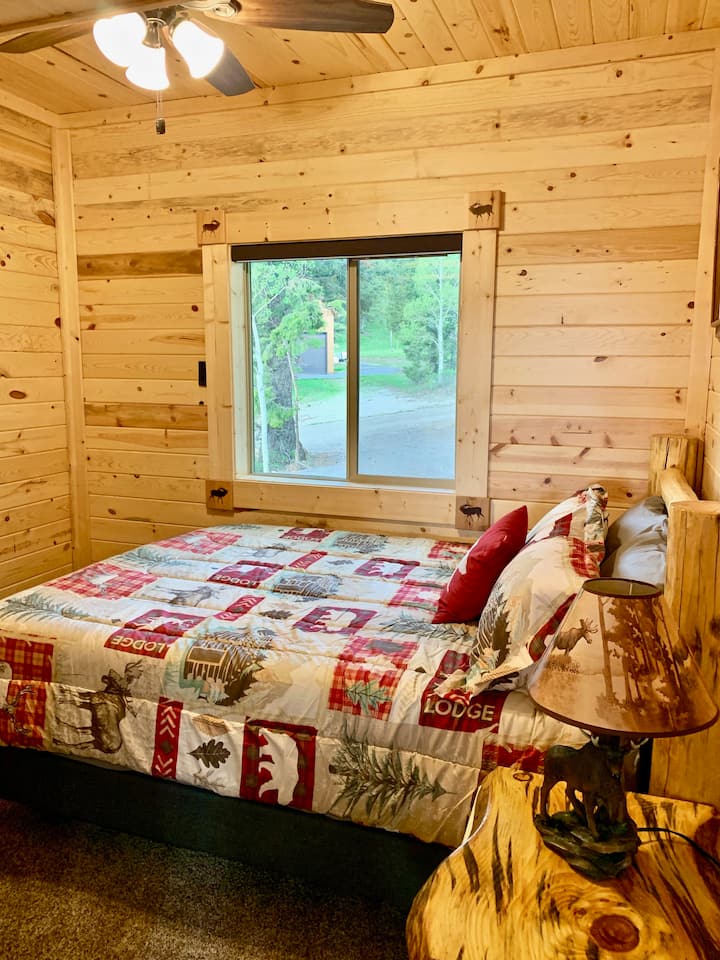 ห้องนอน 2 ชั้นล่างมีเตียงไม้สนขนาดควีนไซส์ 