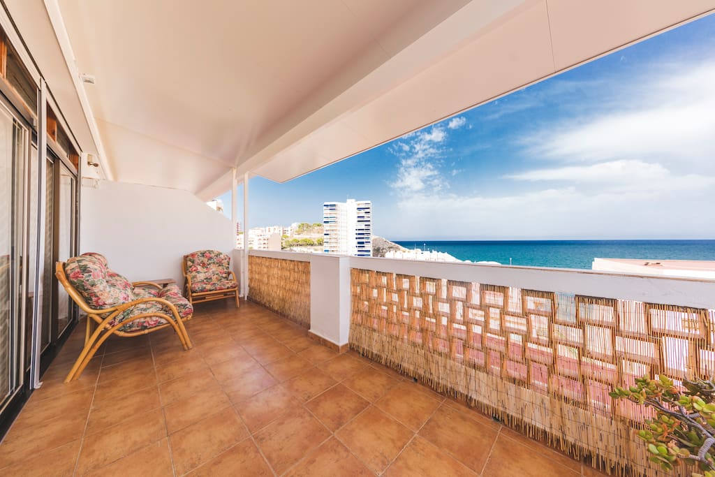 Terraza con vistas a 'Cala del Faro'. Dispone de iluminación, sofás, hamacas para descansar o tomar el sol y amplia mesa para comidas.