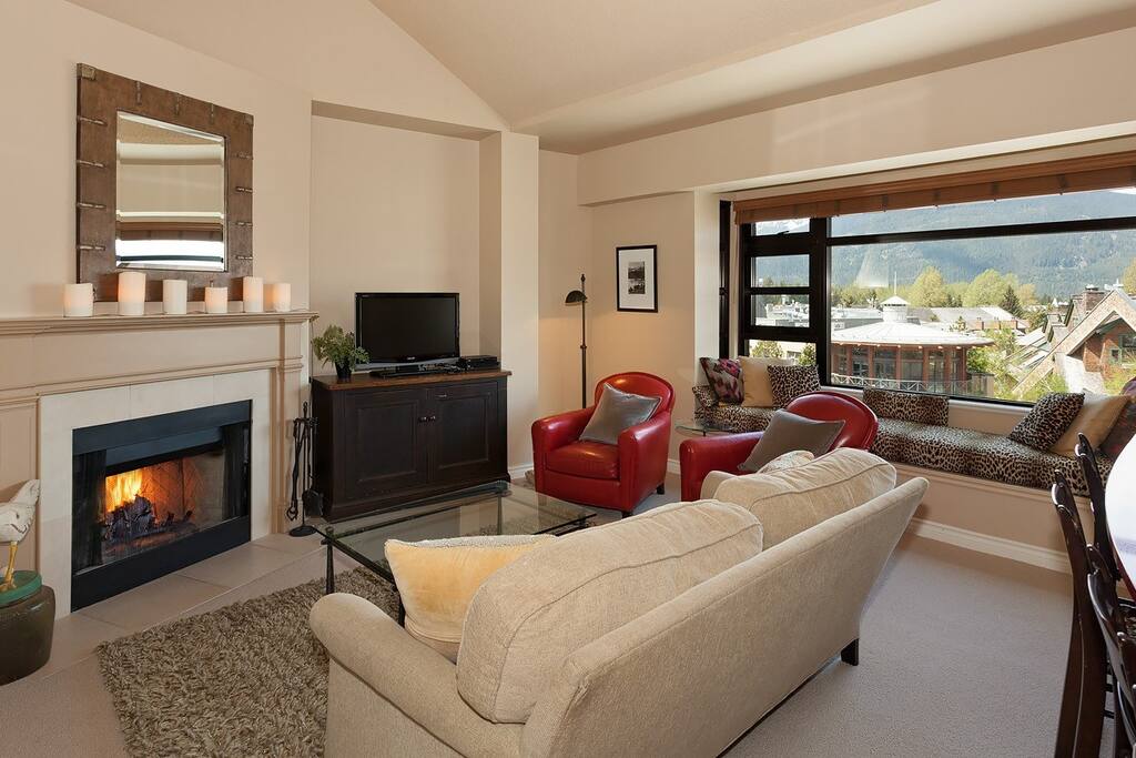 The living room features a wood burning fireplace and lovely reading area where you can take in the view!