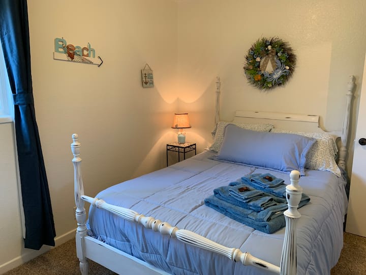 Dormitorio de playa con una cama doble.  Hay muchas cosas divertidas que ver en esta habitación.