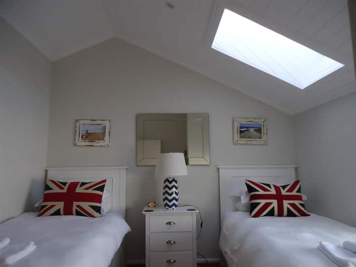 ห้องนอนห้องที่สองอยู่ชั้นบนและมีเตียงเดี่ยวสองเตียง  มีเครื่องนอนและผ้าเช็ดตัวรวมถึงผ้าเช็ดตัวชายหาดกระเป๋าชายหาดที่เป่าผมเตารีดและโต๊ะรีดผ้า