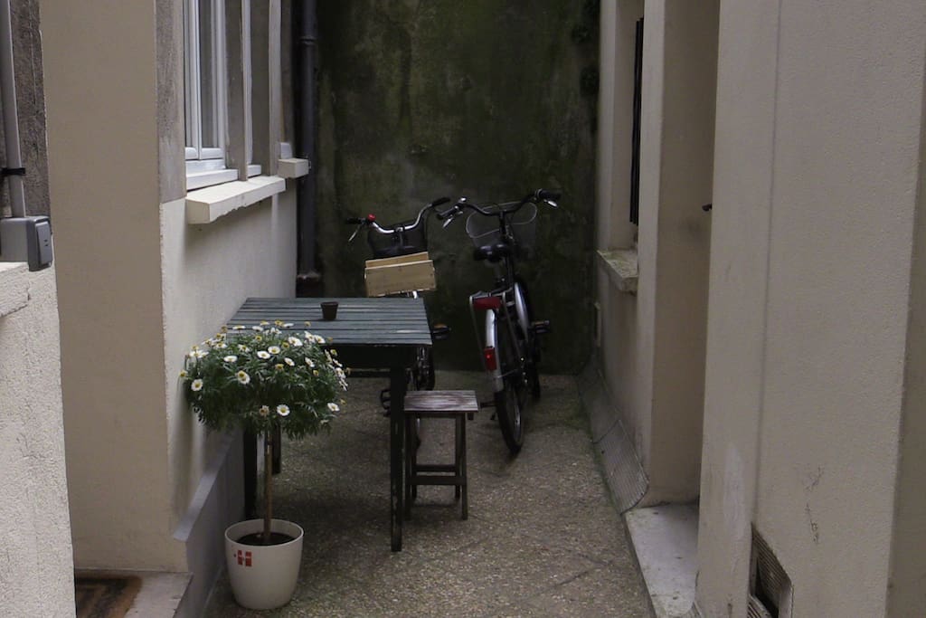Petite cour avec table pour déjeuner et dîner dehors.