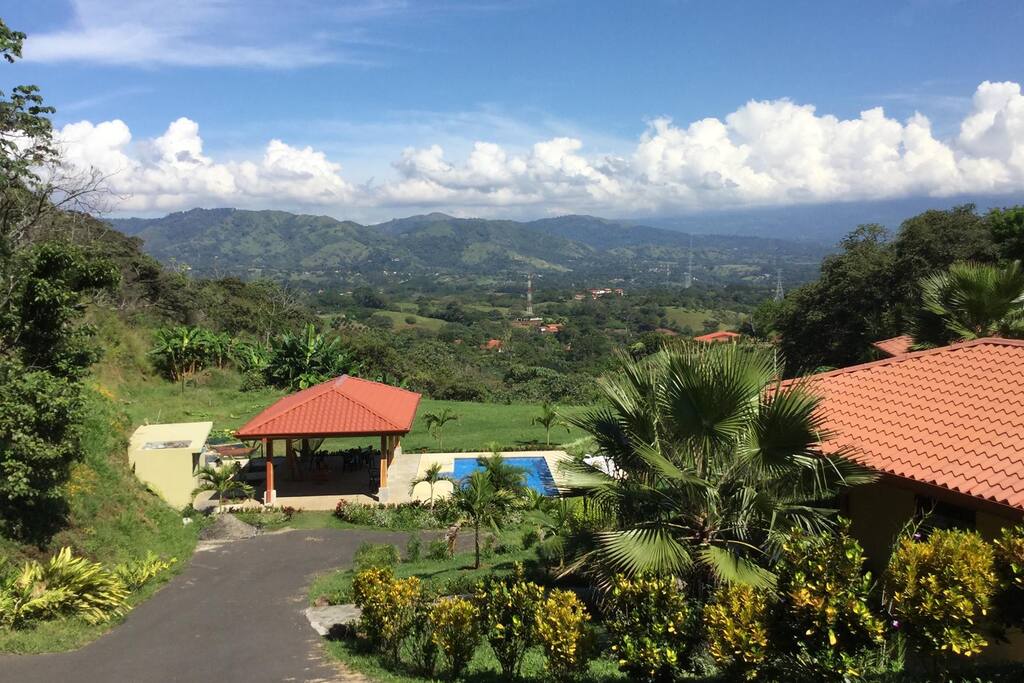 A mountain and valley view with the pool and pool house in the foreground