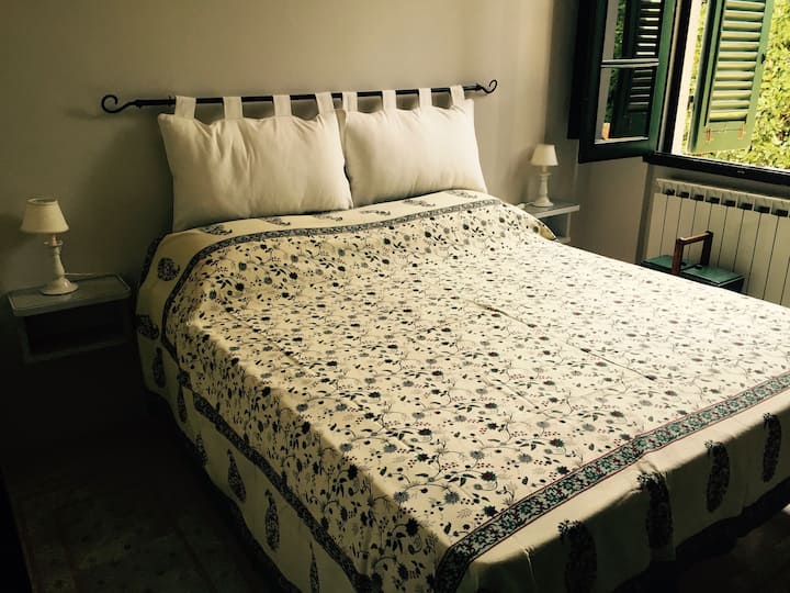 חדר שינה ראשי עם מיטה זוגית וחדר רחצה צמוד