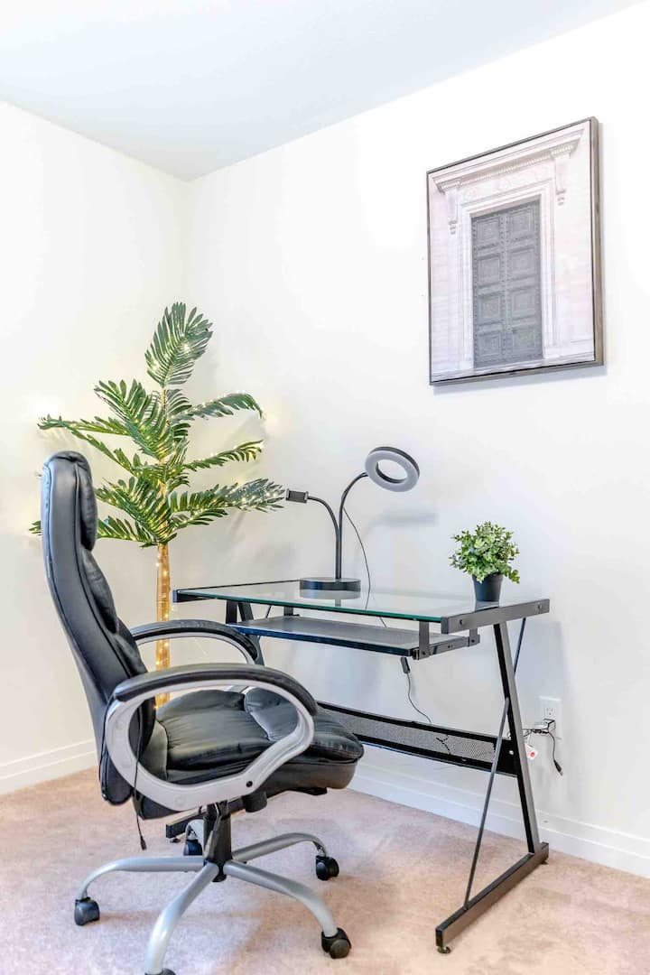 Segundo dormitorio con mesa de oficina y cama tamaño queen