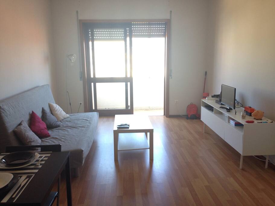 Sala de estar com amplo sofá e tv a cabo.
