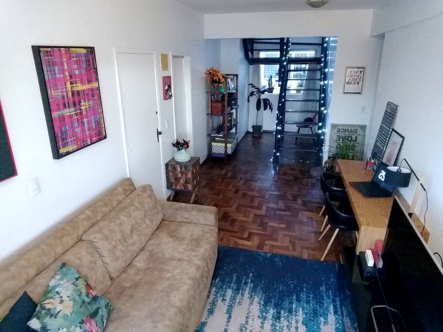 Visão do comprimento da sala com escada para acesso à cobertura ao fundo