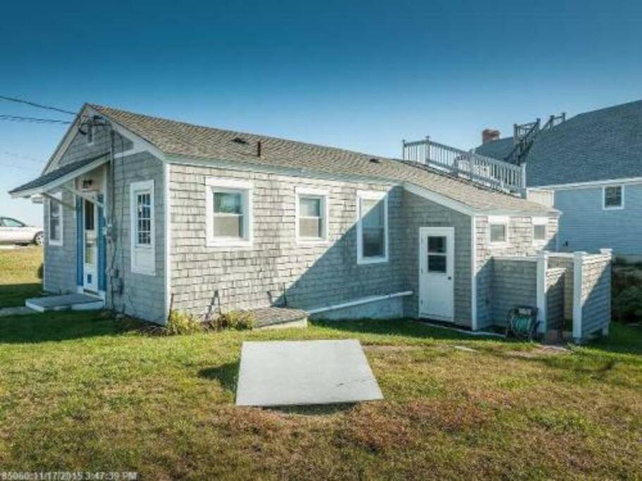 Side view showing outdoor shower and horseshoe pits. There is also a firepit and picnic table.