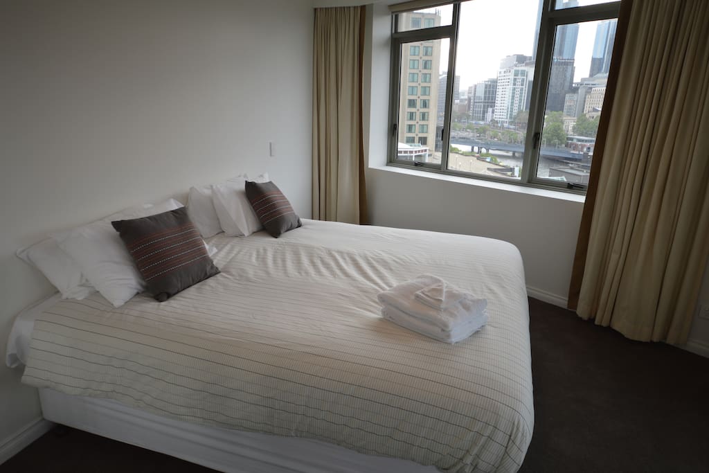The master bedroom looking over Southbank with a king size bed