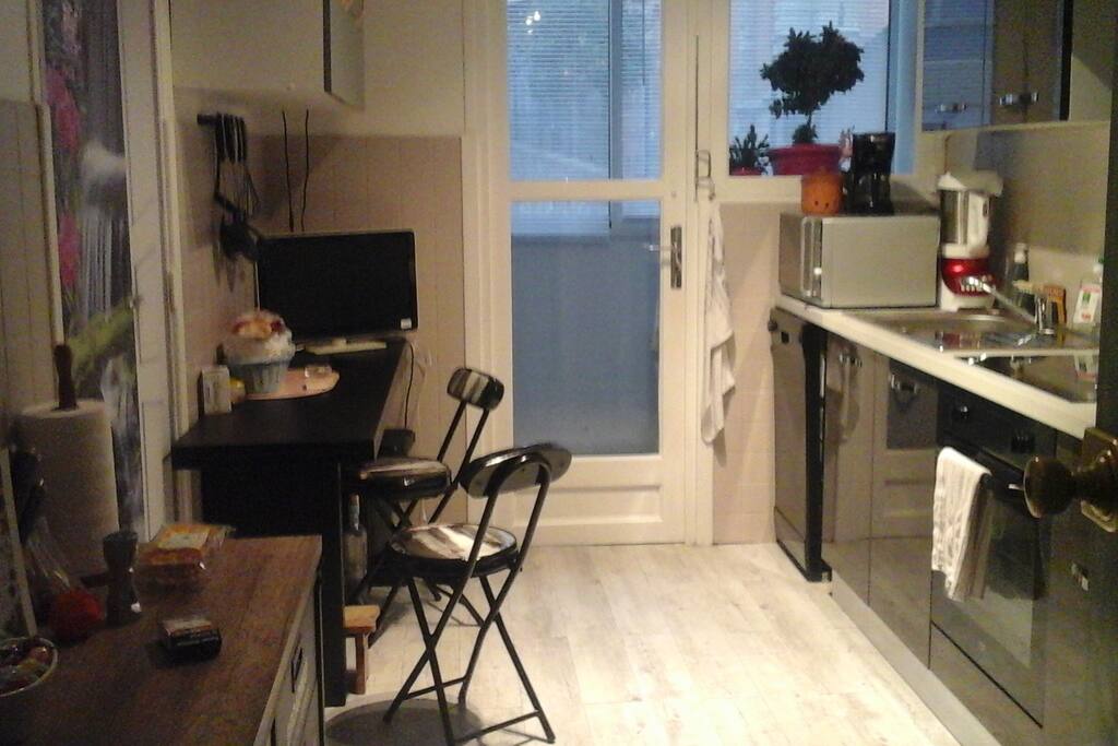 Cuisine aménagée avec lave vaisselle et loggia avec machine à laver