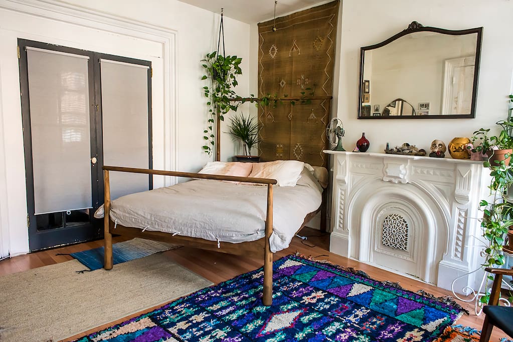Queen size bed with linen duvet, cotton sheets and hand-dyed pillows. French doors leading into living room.