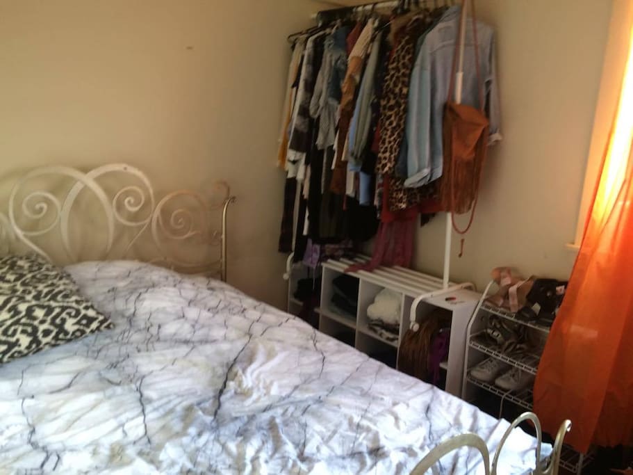 Double bed, clothes rack, cube storage space and shoe rack. Window to the backyard.