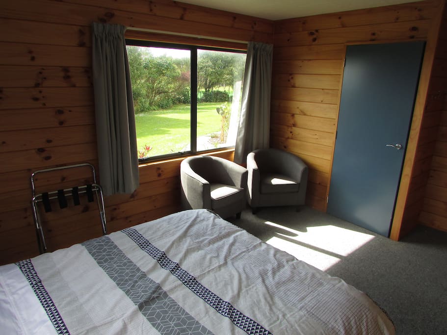 ueen bed with view of garden and sea over the trees. Sunny room