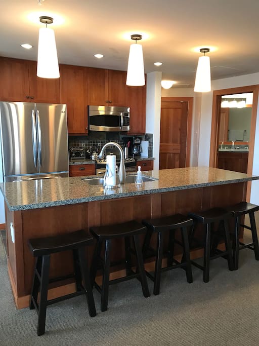Fully Equipped Gourmet kitchen with large island and bar chairs. Stainless steel appliances and granite counter tops.