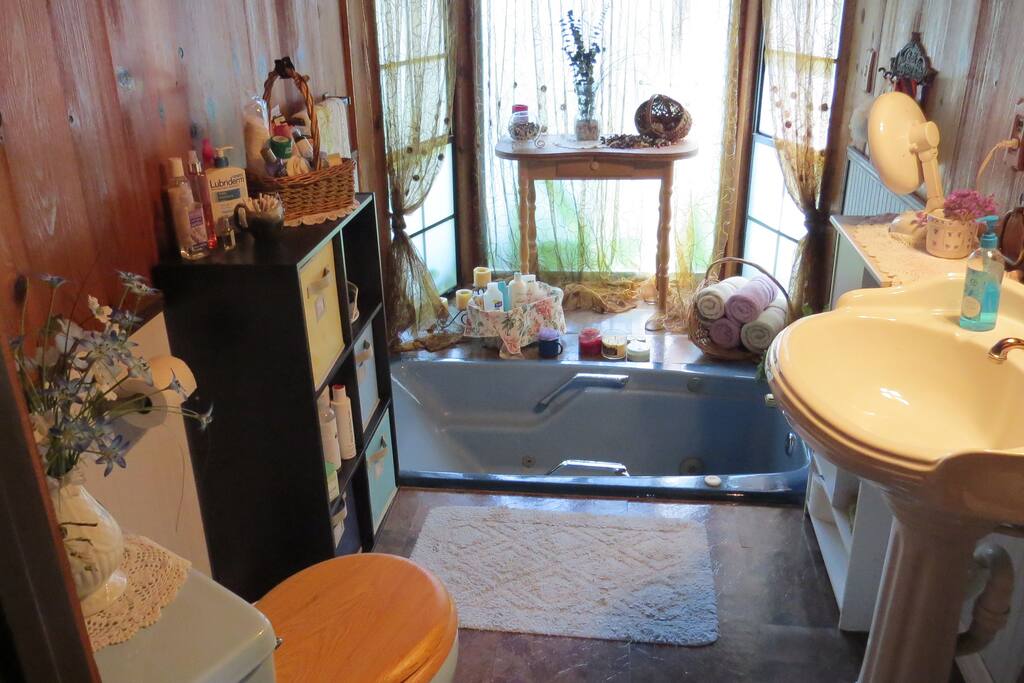 First bathroom has a sunken jacuzzi tub with a bay window. Blow dryer and toiletries on hand.