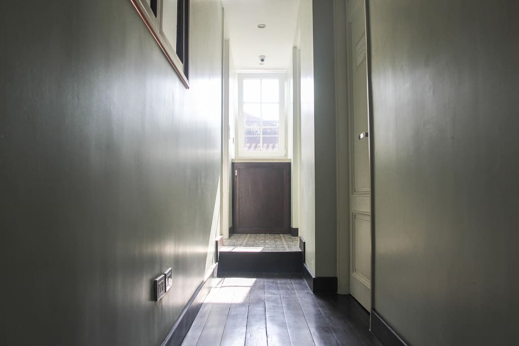 Sunshine filled hallway. In that little cabinet is a washing machine, and yes, it is free for you to use.