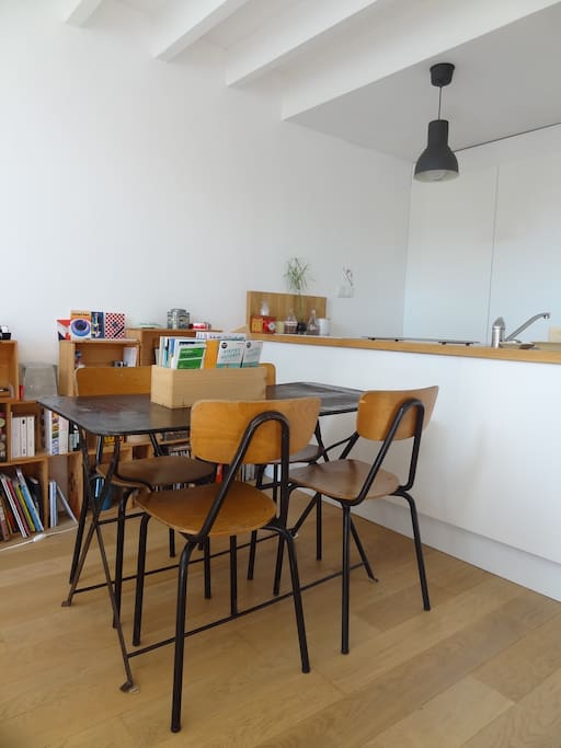 Espace repas avec cuisine en arrière plan