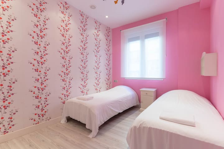 Chambre double équipée de deux lits simples avec entrée de beaucoup de lumière naturelle.