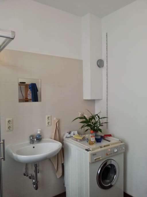 Das Badezimmer mit einer Dusche, einem Waschbecken und einer zweiten Miele Waschmaschine, die mitgenutzt werden kann.