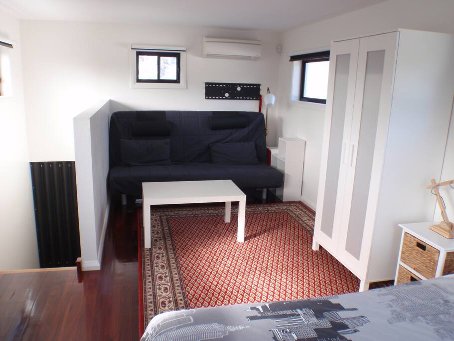 Guest bedroom with sofa, coffee table and wardrobe