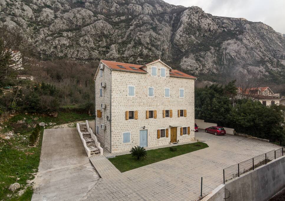 Villa's private, secure parking, with green space behind.