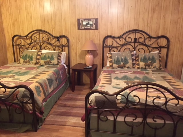 พัดลมเพดานเหนือศีรษะและโต๊ะข้างเตียงพร้อมโคมไฟ