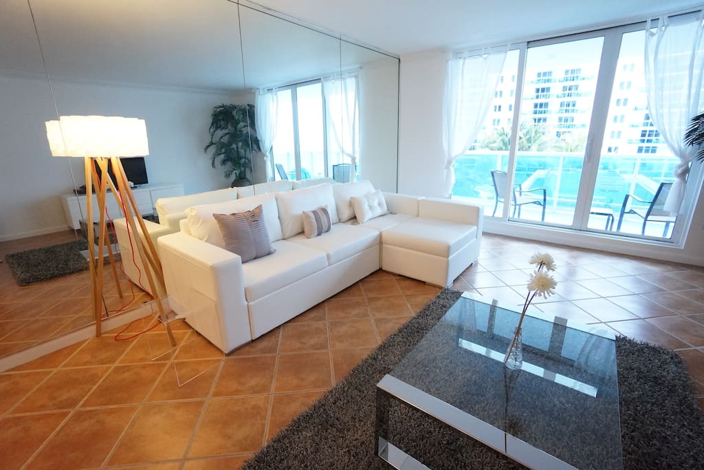 Living room with ocean view reflected in the mirrors and queen sofa bed