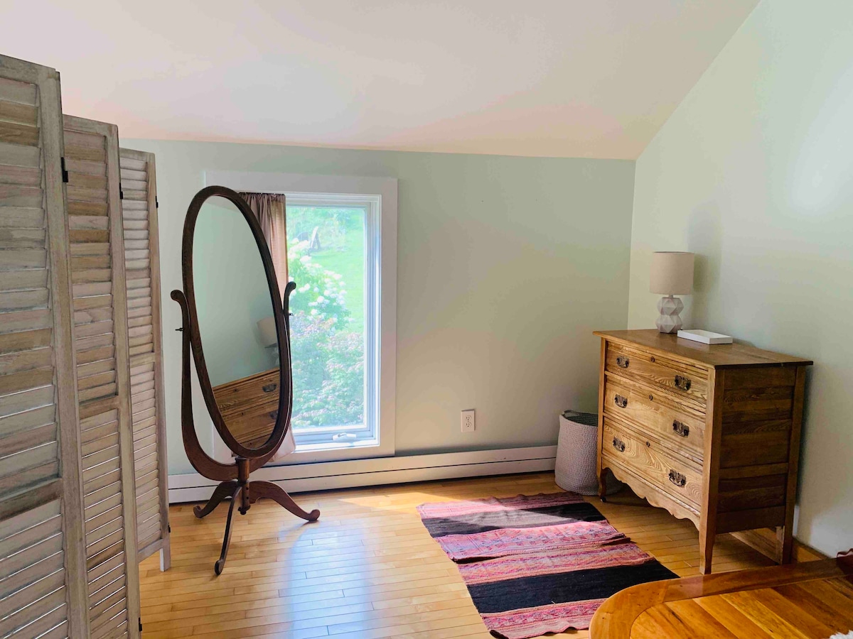 Dresser/dressing area sectioned off from living room area via shutter-door partition. Note, there are no floor-to-cieling walls separating living areas; this is an open studio space. 