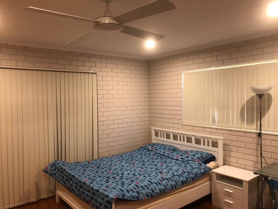 Large bedroom with queen side bed and study desk.