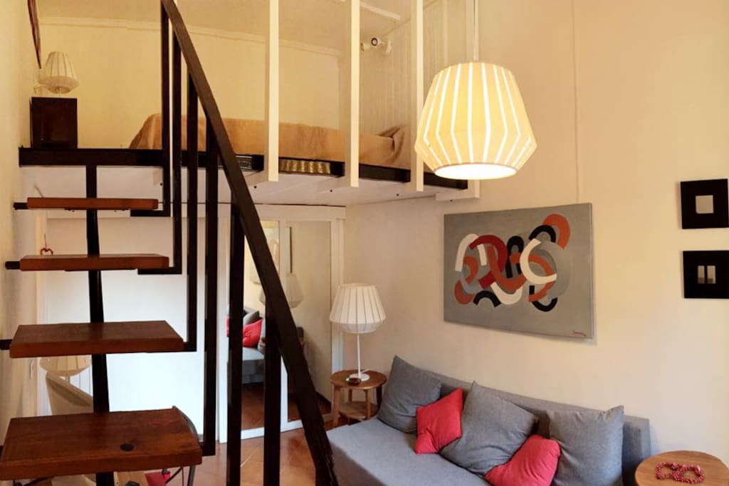 Living room and stairs to the loft area, with a queen size bed.