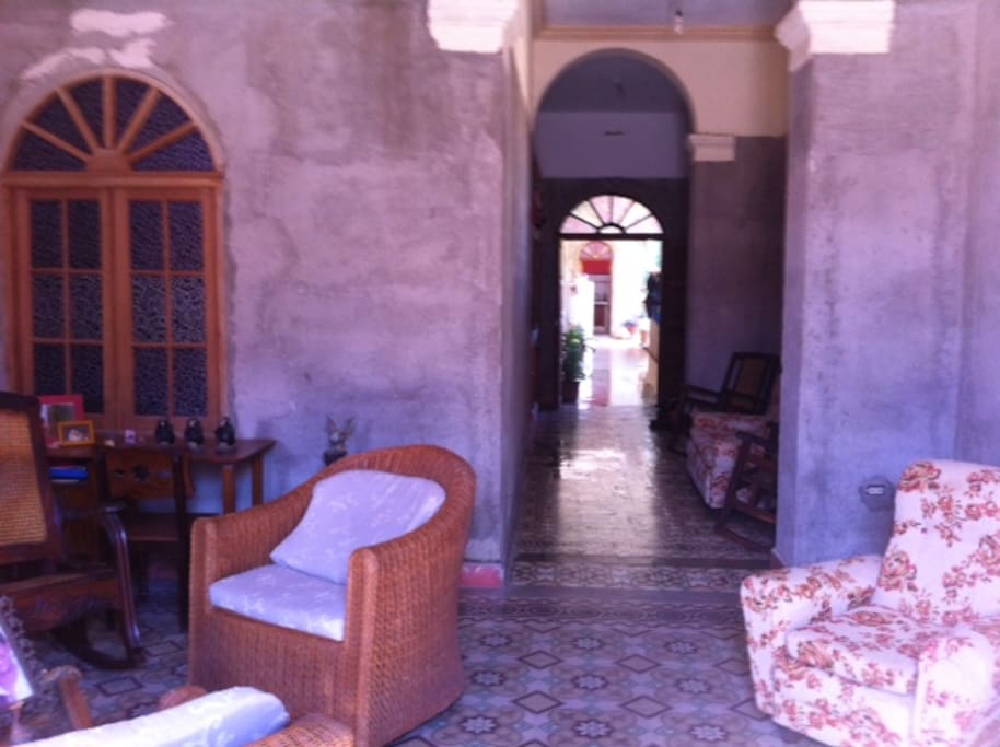 From the living room you have the view of the aisle with the two rooms available for rent to the left and the open kitchen/dining/patio area at the end