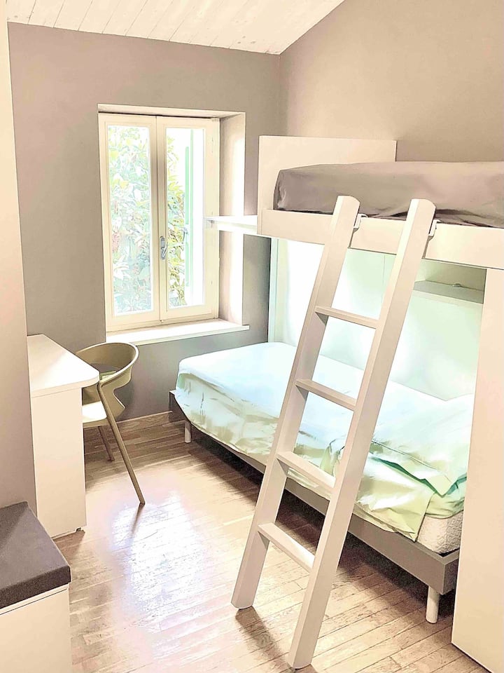 غرفة نوم مع مكتب وسريرين فرديين بطابقين