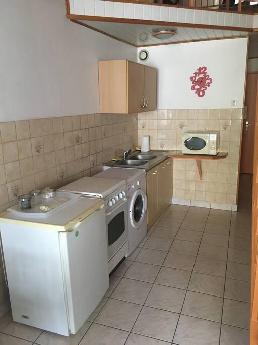Cuisine équipée avec cuisinière, lave linge, micro ondes, cafetière Senseo et bouilloire. Vaisselle mise à disposition.