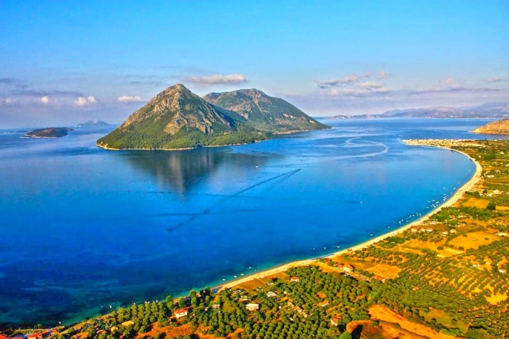 The location and the beach of Paliovarka from above with view of the island's of Kalamos Kastos Ithaka Kefalonia Lefkada and Meganisi