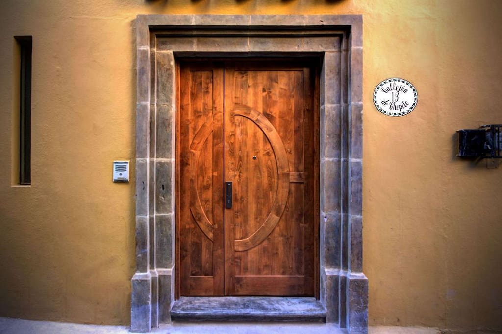 Your vacation awaits through the cantera stone and wood doors, from the callejon.