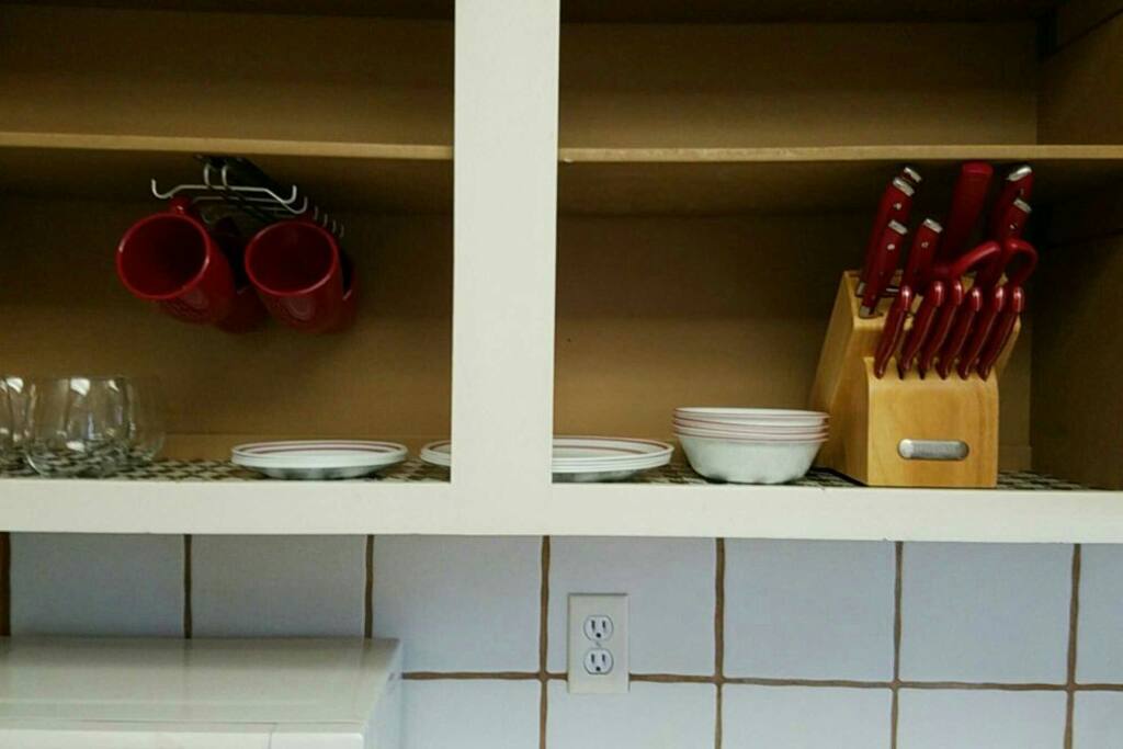 Plates
complete cutlery sets
wine glasses
regular glasses
rice cooker
toaster
blender
bowls
leftover containers
spoon, forks, knives
wine opener
pizza cutter
coffee cups
collander
cutting board
chop sticks
dishwashing detergent
dishwashing clothes