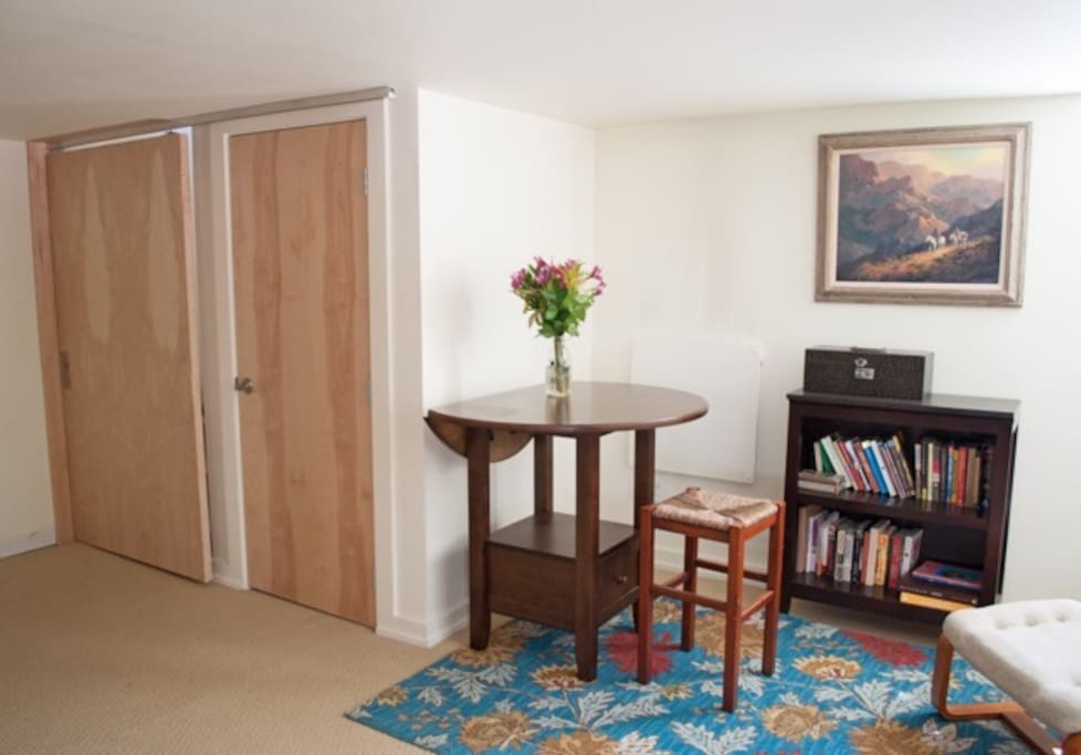 Small "dining" area and reading nook. Door on the right is a closet with linens, towels and other essentials. On the left is a locking "barn" door that separates upstairs and downstairs.