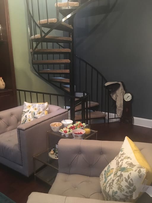 Living room has a large bookcase, and comfy chairs for enjoying a good book.