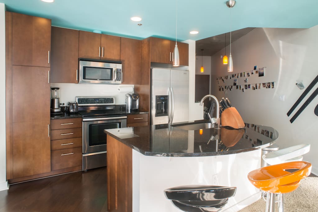 Full, open kitchen with large island. Stainless steel appliances, Keurig, toaster, blender.